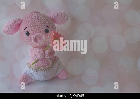 Morbido crochet animale che tiene fiore Foto Stock