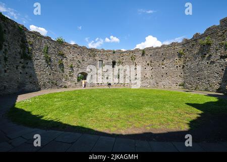 La vista del prato centrale, cortile all'interno delle alte, rotonde, vecchie pareti di pietra circolare del tino. Al Castello di Cardiff, nel Galles, Regno Unito. Foto Stock