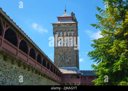La torre dell'orologio in pietra dipinta luminosamente. Creste e figure dorate sulla facciata 24 ore su 24. Al Castello di Cardiff a Cardiff, Galles, United Kin Foto Stock
