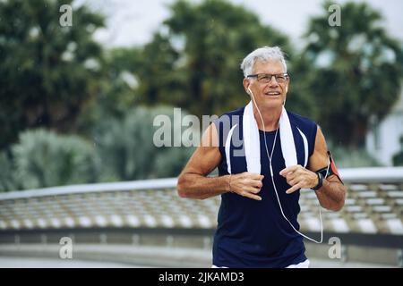 Buon uomo anziano che fa jogging la mattina Foto Stock