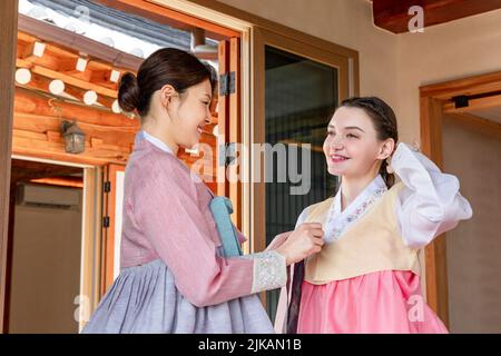 Ragazze coreane e caucasiche che indossano abiti tradizionali coreani Hanbok Foto Stock