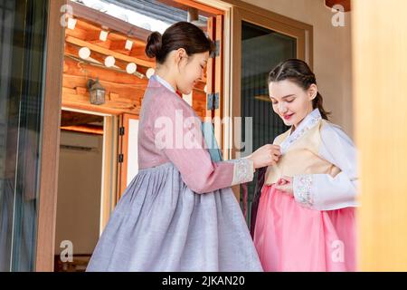 Ragazze coreane e caucasiche che indossano abiti tradizionali coreani Hanbok Foto Stock