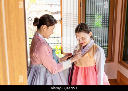 Ragazze coreane e caucasiche che indossano abiti tradizionali coreani Hanbok Foto Stock