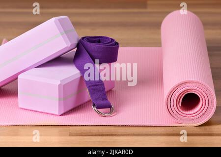 Blocchi yoga, materassino per esercizi e cintura yoga per l'allenamento. Attrezzature per lo yoga. Foto Stock