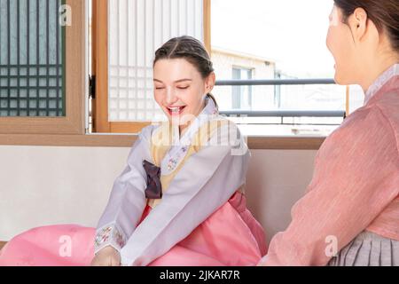 Ragazze coreane e caucasiche che indossano Hanbok giocando a YUT, gioco da tavolo tradizionale coreano Foto Stock