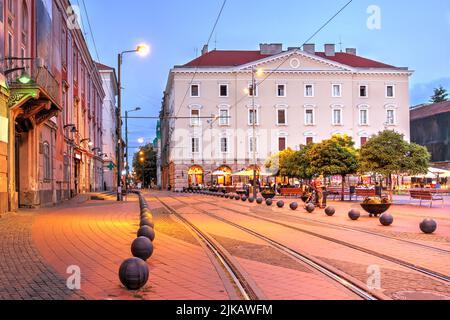 Scena notturna in Piazza della libertà, Timi?oara, Romania. La seconda piazza più antica della città, fu riprogettata nel 2015, pavimentata con mattoni rossi in concentri Foto Stock