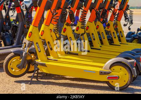 Gli scooter elettrici si trovano in fila presso il punto di noleggio. Foto Stock