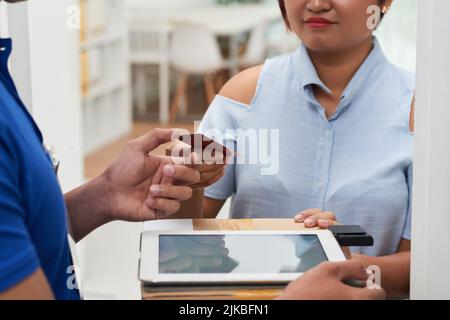 Immagine ravvicinata della donna che gioca con carta di credito per la consegna della pizza Foto Stock