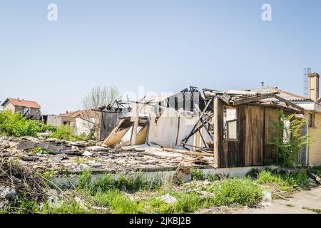 I resti della casa bruciata. Rovinato e crollato casa bruciato e danneggiato nel fuoco con resti di legno di rinforzo pali di tetto selezionare Foto Stock