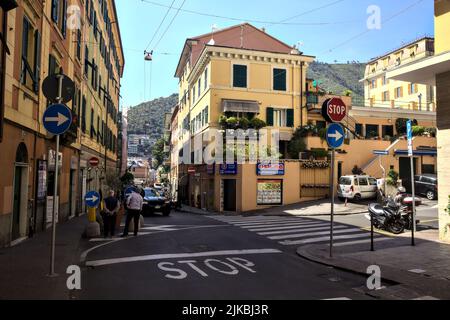 Crocevia tra due strade con auto e gente che passa in una giornata di sole Foto Stock