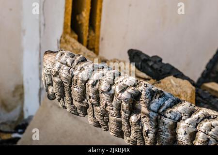 I resti della casa bruciata. Rovinato e crollato casa bruciato e danneggiato nel fuoco con resti di legno di rinforzo pali di tetto selezionare Foto Stock