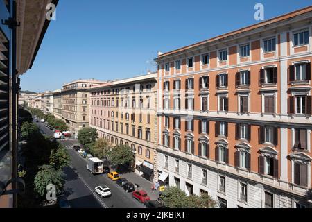 Edificio di appartamenti con balconi e finestre con persiane in pareti in gesso colorato su entrambi i lati di Via Cola di Rienzo nel centro di Roma Foto Stock