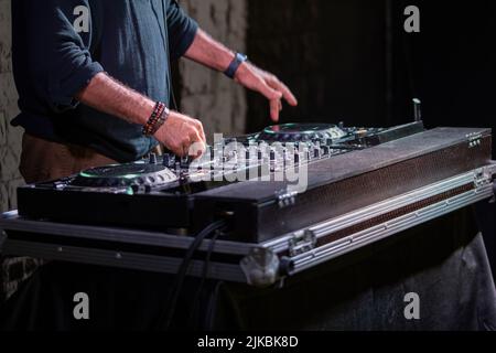 Dj giocare discoteca house progressive electro musica al concerto. DJ le mani su apparecchiature Foto Stock