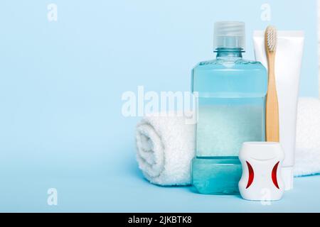 Collutorio e altri prodotti per l'igiene orale sulla vista dall'alto del tavolo a colori con spazio per la copia. Disposizione piatta. Igiene dentale. Prodotti per la cura orale e spazio per il testo o Foto Stock