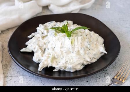 Antipasto di yogurt fresco. Tzatziki asciutto su sfondo di pietra. Cacik a base di menta, insalata e yogurt. Pasti sani. Nome locale kuru cacik .Close up Foto Stock