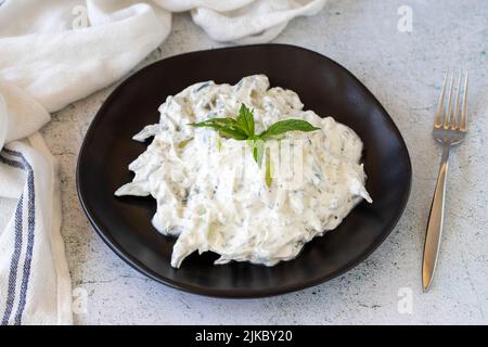 Antipasto di yogurt fresco. Tzatziki asciutto su sfondo di pietra. Cacik a base di menta, insalata e yogurt. Pasti sani. Nome locale kuru cacik .Close up Foto Stock