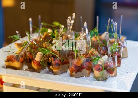 Il servizio di catering piastra .sandwich appetitosi su bastoncini in plastica rangeSandwiches su un tavolo del buffet. carne, pesce, verdura crostini su una festosa wedd Foto Stock