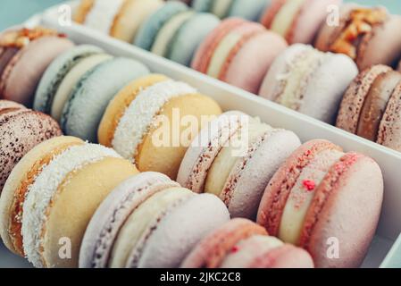 Macaron francese colorato sfondo, primo piano. Gustoso macaroon di colore dolce. Concetto di panetteria. Fuoco selettivo. Foto Stock