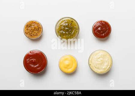 Diversi tipi di salse in ciotole su un pannello colorato . Vista dall'alto, vari salse copia spazio. Foto Stock