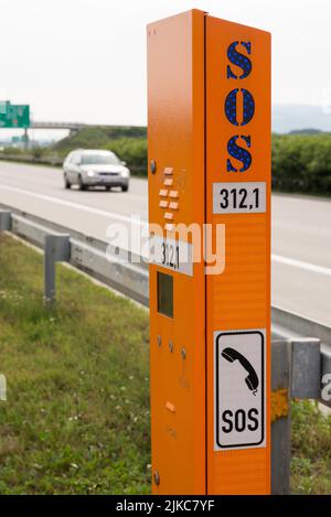 Uno scatto verticale di un segnale SOS per chiamate urgenti in prossimità della strada Foto Stock