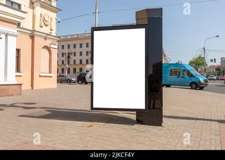 Affissioni mockup in città. Poster verticale per la pubblicità. Marchio, prodotto, servizio, annuncio commerciale su un ampio marciapiede pedonale. Foto di alta qualità Foto Stock