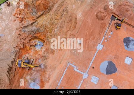 Quando si installano tubi fognari interrati, viene scavata una fossa, in modo da poter completare il collegamento della rete fognaria Foto Stock