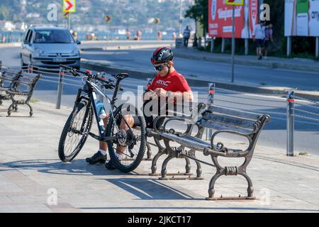 Istanbul, Turchia. 30th luglio 2022. Un giovane ciclista visto riposarsi sul mare del Bosforo. I cittadini che sudano nel calore di Eyyam-? Bahur, che ha iniziato il fine settimana a Istanbul, si è raffreddata sul Bosforo. Credit: SOPA Images Limited/Alamy Live News Foto Stock