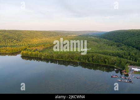 Il sole nel tardo pomeriggio splende sul lago Owasco e sull'insenatura di Owasco vicino a Moravia, nella contea di Cayuga, New York. Un piccolo porticciolo è sulla destra. Foto Stock