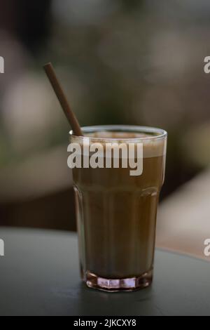 Caffè ghiacciato in tazza con sfondo sfocato Foto Stock