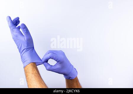 due mani umane in guanti chirurgici in nitrile blu, sicurezza medica professionale e igiene per chirurgia e visita medica su sfondo bianco. Lo Foto Stock