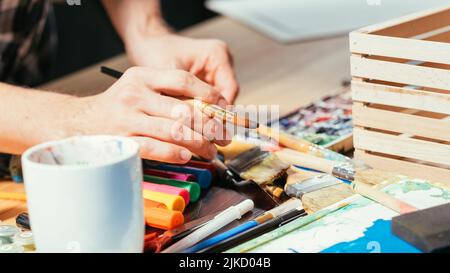 strumenti per artisti pennelli marcatori mani posto di lavoro Foto Stock