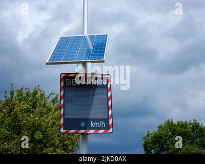 Basilea, Svizzera - Luglio 4 2022: Segnale di velocità con display a energia solare: Andando al di sotto del limite di velocità. nuvoloso giorno d'estate Foto Stock
