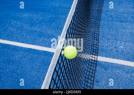 una palla in aria sulla rete di un campo da paddle tennis, concetto di racket sport Foto Stock