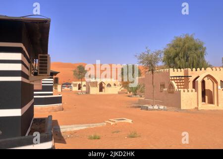 Campeggio in stile beduino accanto ad una enorme duna di sabbia nel deserto di Wahiba Sands in Oman. Foto Stock