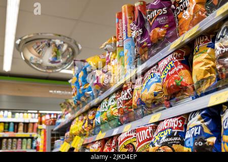 Un sacco di patatine e patatine in un minimarket Zabka, esposizione prodotti, gruppo di oggetti primo piano, nessuno, nessuna gente, interno negozio, negozio interno, Foto Stock