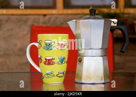 Primo piano di un abbraccio con caffettiera su tavola di legno Foto Stock