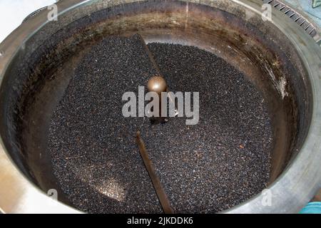 Un seme del cumino nero nel tostatore rotante. Foto Stock