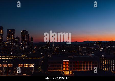 Tramonto con lo skyline del centro di Seattle, le Olympic Mountains, luna crescente dal ponte sul tetto di Capitol Hill Foto Stock
