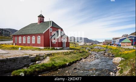 La chiesa dei saviors con il fiume che corre lungo a Qaqortoq, Groenlandia il 13 luglio 2022 Foto Stock