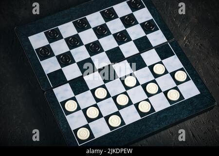 Scacchiera con chip sfondo nero, gioco da scacchiera logica Foto Stock