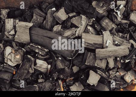 Legno che brucia. Il resto dell'alveare. Legna da ardere. Ceneri nel cavoldro. Resti del fuoco. Foto Stock