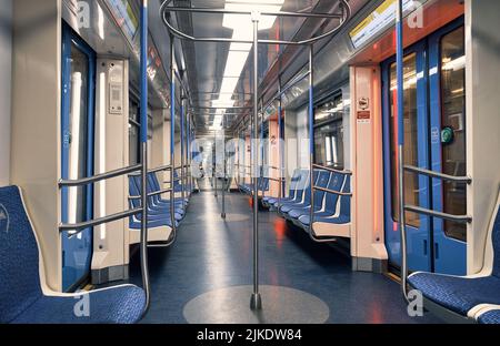 Interno di un moderno treno metropolitano con un piccolo gruppo di passeggeri in lontananza: Mosca, Russia - 16 luglio 2022 Foto Stock