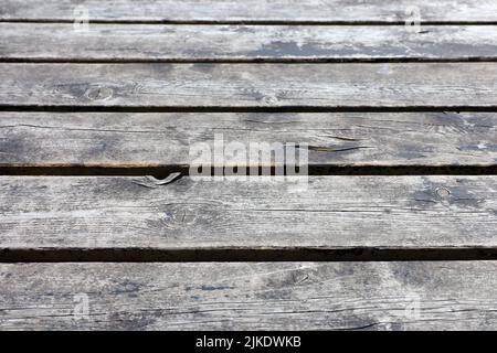 Vecchi assi di legno, texture pavimento. Pannelli grigi con spazi e vernice resistente agli agenti atmosferici per lo sfondo Foto Stock