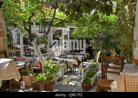 Rodi, Grecia - Maggio 2022: Area salotto all'aperto nel giardino di una tradizionale taverna greca nella città vecchia di Rodi Foto Stock