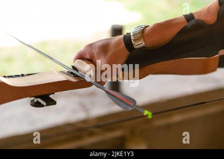 Mano che tiene un arco e una freccia Foto Stock