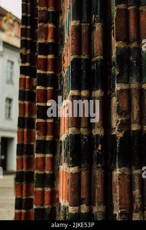 La parete di mattoni rosso-verde dell'edificio. Foto verticale Foto Stock