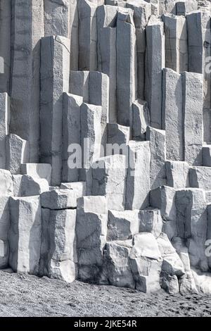 Dettaglio delle colonne di basalto alla base della scogliera di Reynisfjall nella spiaggia di Reynisfjara nell'Islanda meridionale Foto Stock