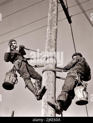 1930S DUE UOMINI LINEMEN ELETTRICI INSTALLAZIONE DI LINEE DI ALIMENTAZIONE SU UN POLO DI UTILITÀ IN LEGNO - I3343 HAR001 HARS LAVORO MIGLIORI LINEE DI LAVORO PROFESSIONI INFRASTRUTTURA DIPENDENTI STRUTTURE NUCLEO LINEMEN MEDIO-ADULTO MEDIO-ADULTO UOMO SISTEMI GIOVANE ADULTO UOMO NERO E BIANCO CAUCASICO ETNIA ECONOMIA HAR001 INSTALLAZIONE LABORING VECCHIO STILE Foto Stock