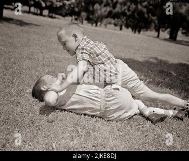 1950S DUE RAGAZZI CHE GIOCANO A WRESTLING COMBATTENDO NEL CORTILE ERBOSO - J7507 HAR001 HARS AMICIZIA MEZZA LUNGHEZZA MASCHI FRATELLI B&W ESTATE ALTA ANGOLATURA AVVENTURA STRESSATA FORZA ROTTAMI IRATE ECCITAZIONE ORGOGLIO WRESTLING FRATELLO CONCETTUALE AMICHEVOLE ERBOSO DISPIACERE OSTILITÀ BRAWL AGGRESSIVO FASTIDIO EMOTIVO EMOZIONE CRESCITA IRRITATA GIOVANI STAGIONE AGGRESSIONE NERO E BIANCO ETNIA CAUCASICA DISPIACIUTA HAR001 VECCHIO STILE Foto Stock