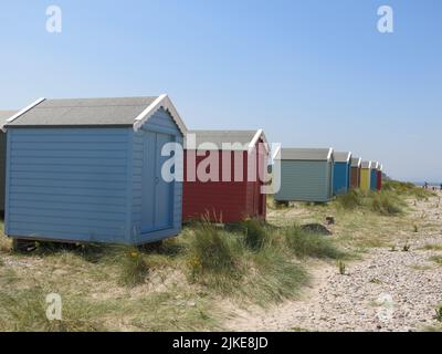 Gemme marine nascoste della Scozia: Colorate capanne in fila sulle dune di sabbia sulla spiaggia di Findhorn, sulla costa NE Moray della Scozia. Foto Stock